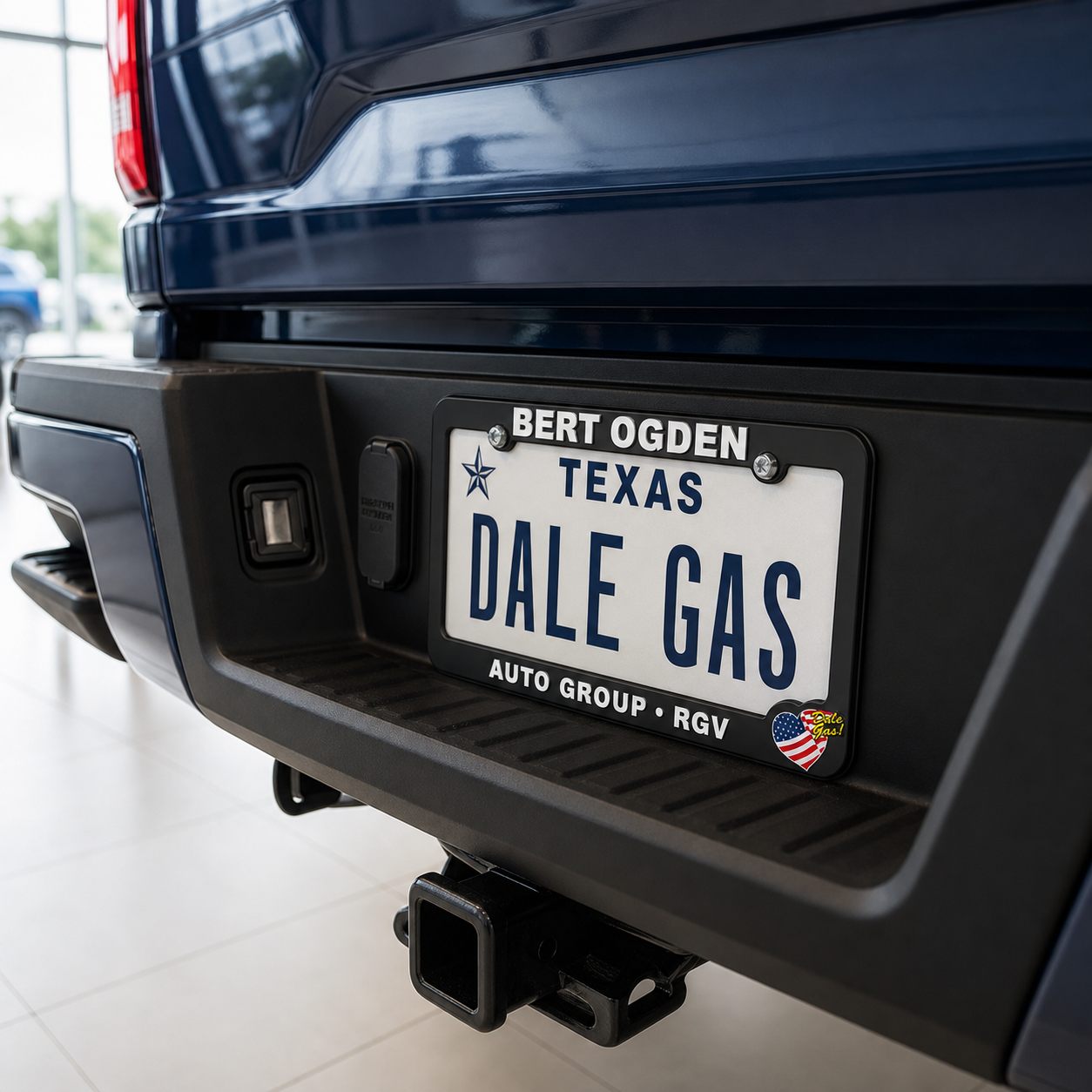 Bert Ogden license plate frame installed on a navy truck